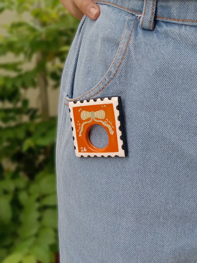 Handmade Bright Boho Orange Postage Stamp Clay Sunglasses Glasses Holder Brooch — Hand-Painted Bow Statement Reading Glasses Holder Brooch For Denims, Tote bags, Hand bags and Shirts