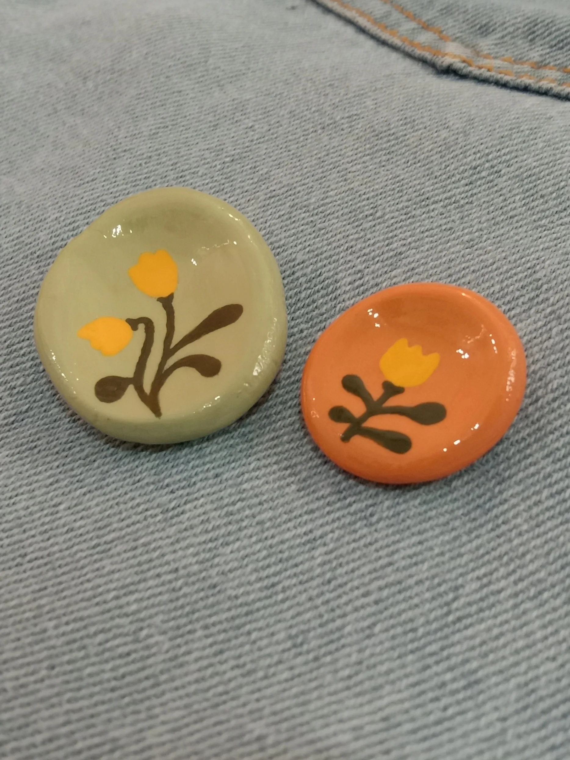 Low angle shot highlighting the premium glossy glaze finish over the hand-painted details on a clay stress stone.